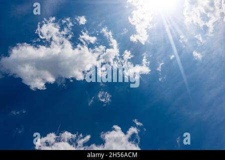 Beau ciel bleu avec des cumulus blancs et des rayons de soleil (rayons de soleil).Photographie en contre-jour. Banque D'Images