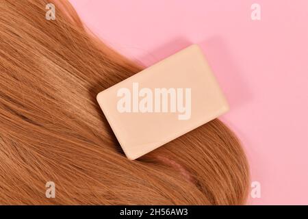 Barre de shampooing solide avec des cheveux sains sur le backgorund rose Banque D'Images