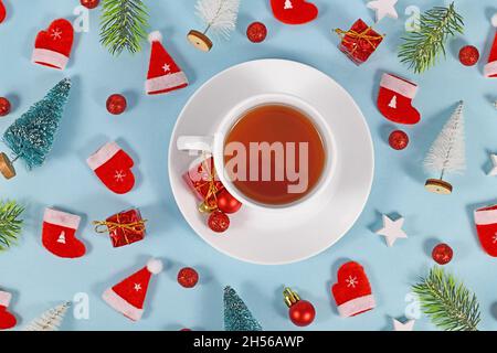 Tasse de thé entourée d'une décoration de Noël de saison sur fond bleu Banque D'Images