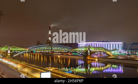 Vue sur le pont coloré Bogdan Khmelnitsky illuminé la nuit et réfléchissant dans la rivière Moskova.Pont piétonnier traversant la rivière Moskva.Moscou Banque D'Images