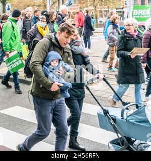 Amsterdam, pays-Bas, 06 novembre 2021.Une famille avec un jeune bébé marche entre d'autres participants du barrage au Westerpark pendant le mois de mars climat, organisé par la Climate Crisis Coalition, une collaboration de 11 organisations.Credit: Steppeland/Alay Live News Banque D'Images