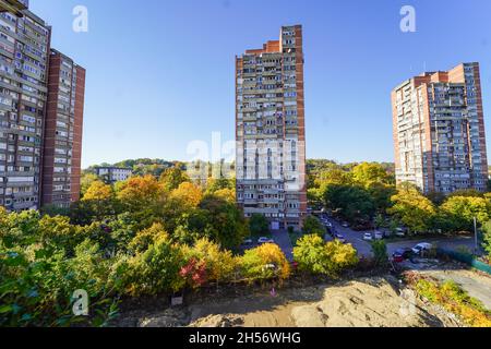 Image large du nouveau bloc de Belgrade 4 bâtiments de l'ère socialiste pendant l'automne avec différentes couleurs sur les arbres de la rue Banque D'Images