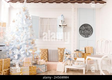 Sapin de Noël blanc décoré de boules de Noël argentées roses dorées et de belles boules de verre sur branche blanche bleue étincelante et fée, décoratif Banque D'Images