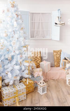 Sapin de Noël blanc décoré de boules de Noël argentées roses dorées et de belles boules de verre sur branche blanche bleue étincelante et fée, décoratif Banque D'Images