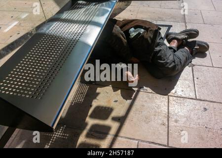 Perpignan, France, scènes de rue, sans-abri dormant sur le trottoir près de la gare, sous le banc public à la gare routière, pauvreté publique Banque D'Images