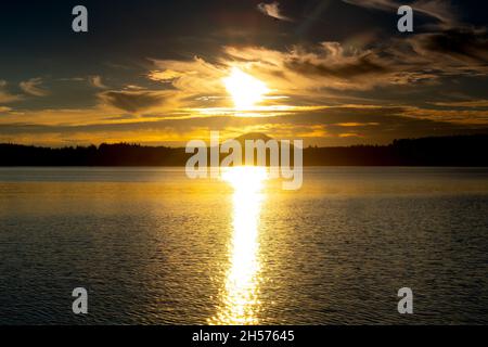 Quinault, WA - États-Unis - sept21, 2021 : vue horizontale du coucher de soleil sur le Lake Quinault Lodge dans le parc national olympique.Ciel doré avec la réflectine du soleil Banque D'Images