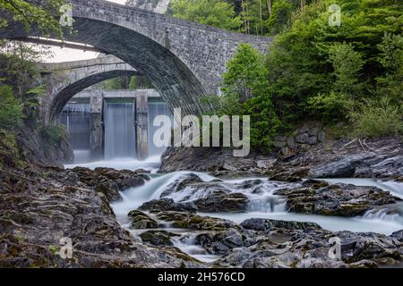 Une cascade derrière un vieux pont Banque D'Images