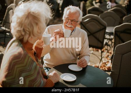 Un couple de personnes âgées en bonne santé qui boit du café en plein air le jour ensoleillé de l'automne Banque D'Images