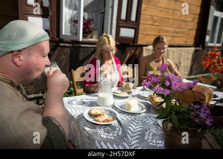 Son boit du lait de vache frais dans un verre.Petit déjeuner à la campagne. Banque D'Images