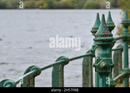 Rambardes de pont en métal vert en face d'un lac Banque D'Images