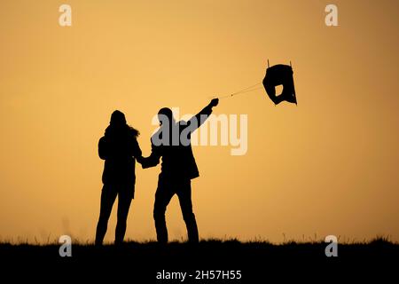 Berlin, Allemagne.07th nov. 2021.La silhouette de deux personnes peut être vue en volant d'un cerf-volant avant le coucher du soleil à Berlin, le 7 novembre 2021.Copyright: Florian Gaertner/photothek.de crédit: dpa/Alay Live News Banque D'Images