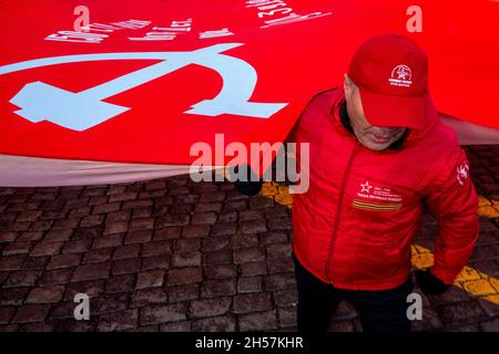 Moscou, Russie.7 novembre, 2021 partisans du parti communiste arborent un immense drapeau rouge en se dirigeant vers le mausolée du fondateur soviétique Vladimir Lénine sur la place Rouge pour marquer le 104e anniversaire de la Révolution du 1917 octobre, à Moscou, en Russie Banque D'Images