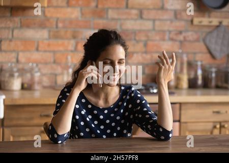 Une jeune femme latine positive au foyer parle au téléphone à son mari Banque D'Images