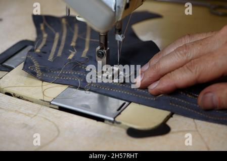 Machine à coudre industrielle professionnelle à serrure dans un atelier de cordonnerie.Équipement pour la bordure, le hemming ou le coutures des chaussures en cuir faites à la main Banque D'Images