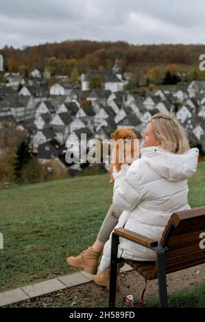 Jeune femme avec un joli pompon spitz dans la belle vieille ville allemande Freudenberg Banque D'Images
