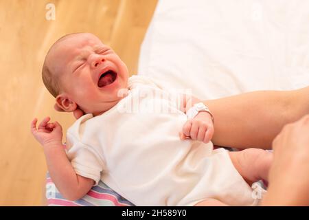 Maman tient son bébé hurlant dans ses bras Banque D'Images