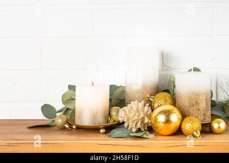 Décorations de Noël intérieur - étagère avec bougies, branches d'eucalyptus et décor doré. Banque D'Images