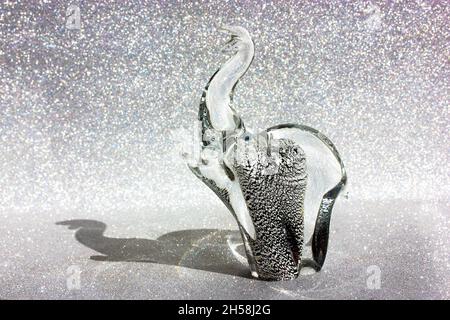 Figurine éléphant en verre de Murano, ombre contrastée sur un fond brillant argenté.Figurine animale.Talisman protège contre les mauvais esprits.Souv Banque D'Images