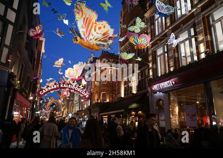 Londres, Royaume-Uni, 7 novembre 2021 : le dimanche après-midi, le West End de Londres regorge de clients qui profitent du temps sec pour faire du shopping.Les lumières de Noël au-dessus de Carnaby Street présentent des papillons multicolores, des présentoirs spéciaux sont dans les vitrines de magasin et parler de problèmes de chaîne d'approvisionnement signifie que les détaillants encouragent les gens à faire leurs achats de Noël tôt.Anna Watson/Alay Live News Banque D'Images