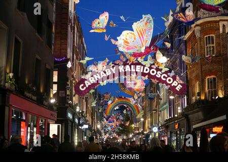 Londres, Royaume-Uni, 7 novembre 2021 : le dimanche après-midi, le West End de Londres regorge de clients qui profitent du temps sec pour faire du shopping.Les lumières de Noël au-dessus de Carnaby Street présentent des papillons multicolores, des présentoirs spéciaux sont dans les vitrines de magasin et parler de problèmes de chaîne d'approvisionnement signifie que les détaillants encouragent les gens à faire leurs achats de Noël tôt.Anna Watson/Alay Live News Banque D'Images