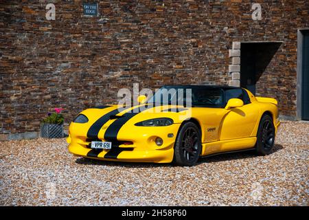 Jaune Dodge Viper SRT 10 garé sur un terrain en gravier devant une maison et un garage Banque D'Images