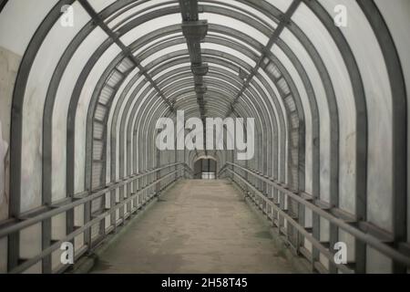 Long tunnel dans l'après-midi.Couloir en acier avec lumière naturelle.Passage piéton de l'autre côté de la rue.La route pour les gens.Architecte de transport urbain Banque D'Images
