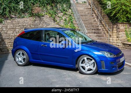 Ford Focus RS (2003) stationné dans une rue résidentielle urbaine étroite, sous un mur en pierre bancarisé Banque D'Images