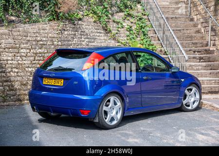 Ford Focus RS (2003) stationné dans une rue résidentielle urbaine étroite, sous un mur en pierre bancarisé Banque D'Images