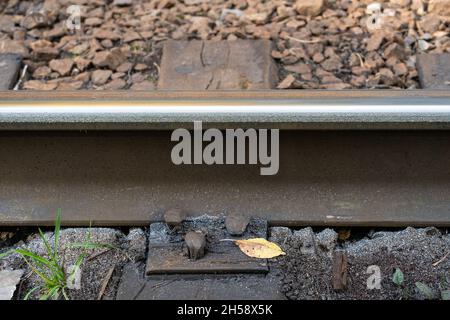 Gros plan de l'usure latérale accrue des rails en acier avec des copeaux métalliques dans une courbe très raide. Banque D'Images