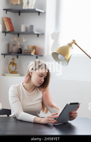 Concept, jeune femme d'affaires travaillant et magasiner en ligne au bureau sur tablette, photo verticale. Banque D'Images