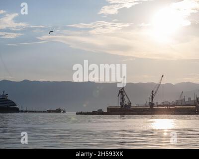 Photo de grues au coucher du soleil sur les quais dans le port de Rijeka.Le Port de Rijeka est un port maritime à Rijeka, en Croatie, situé sur les rives de la Kvarn Banque D'Images