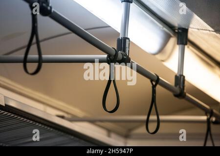 Photo d'une poignée dans un train de banlieue, à l'intérieur, sans personne. Ces griffes sont utilisées par les passagers. Banque D'Images