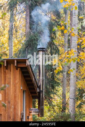 Une cabine en bois dans une forêt pendant un froid jour d'automne, fumée sortant de la cheminée.Détails d'une cabane en bois.Photo de voyage, personne, choisir Banque D'Images