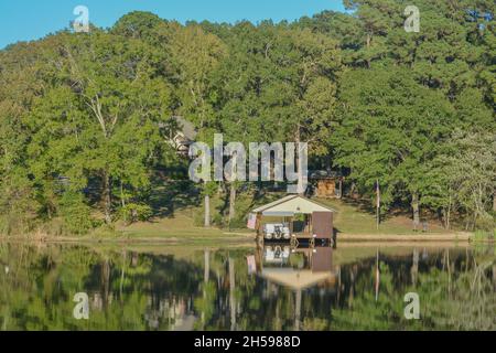 Image miroir sur le lac Cherokee de maisons de bateau et d'arbres.À East Henderson, comté de Rusk, Texas Banque D'Images