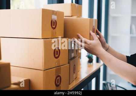 Gros plan de la main de démarrage petit entrepreneur d'affaires choisissant la boîte avant d'envoyer au client, en ligne affaires et le concept de livraison. Banque D'Images