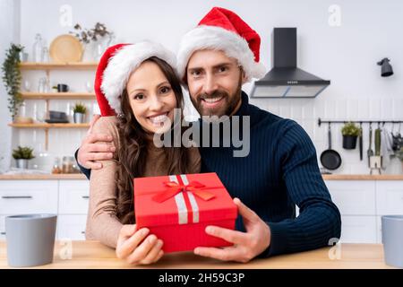 Portrait d'un couple affectueux et sincère qui reçoit un cadeau qui regarde l'appareil photo Banque D'Images