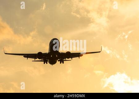 Silhouette sombre d'un avion à l'approche du coucher du soleil dans l'aéroport d'un beau ciel Banque D'Images