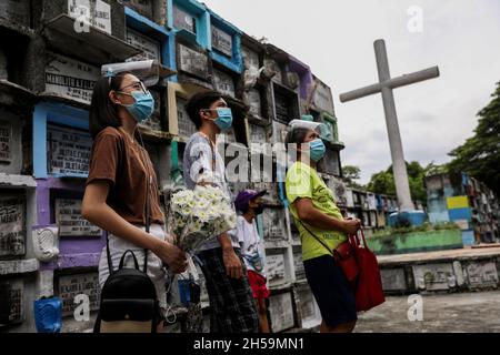 Les gens offrent des fleurs dans un cimetière public à l’occasion de la Journée de tous les âmes à Quezon City, dans la région métropolitaine de Manille, aux Philippines. Banque D'Images