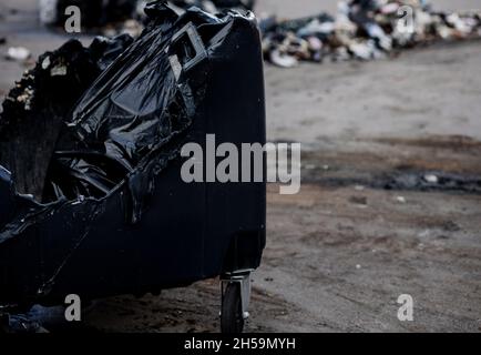 Poubelle fondue dans la rue.Des parasites inconnus ont brûlé une poubelle en plastique. Banque D'Images