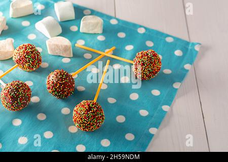 Des petits gâteaux - cakepops pour l'anniversaire des enfants sur un fond de bois blanc. Banque D'Images