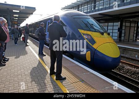Train à grande vitesse arrivant à Ashford International plate-forme arrière homme en costume personnes qui attendent d'embarquer pour aller à la gare de St Pancras Londres UK KATHY DEWITT Banque D'Images