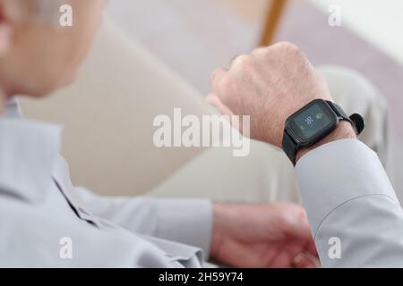 Homme d'affaires utilisant l'application sur la montre intelligente pour contrôler l'impulsion Banque D'Images