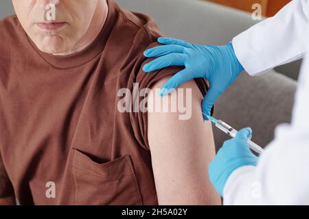 Image en gros plan d'un homme âgé qui se vaccine contre le coronavirus à la maison Banque D'Images