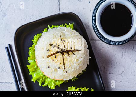 Hamburger de riz avec escalopes de saumon, sauce à l'avocat et au soja, fond gris, vue de dessus, gros plan. Banque D'Images