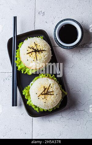 Hamburger de riz avec escalopes de saumon, sauce à l'avocat et au soja, fond gris, vue de dessus, espace de copie. Banque D'Images