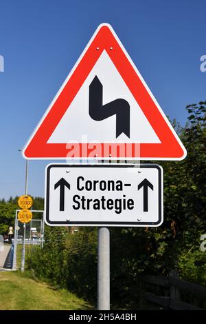 FOTOMONTAGE, Schild mit KurvenSymbol und Aufschrift Corona-Strategie, Symbolfoto fuer Schlingerkurs in der Corona-Pandemiebekaempfung Banque D'Images