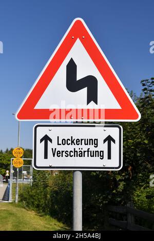 FOTOMONTAGE, Schild mit KurvenSymbol und Aufschrift Lockerung und Verschaerfung, Symbolfoto fuer Schlingerkurs in der Corona-Pandemiebekaempfung Banque D'Images