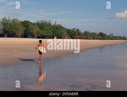 surfez sur les planches de surf blanches en marchant le long de la plage. bali Banque D'Images