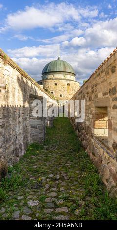 Vadstena, Suède - 23 mai 2021 : chemin intérieur entre les murs du château dans la ville suédoise de Vadstena avec tour à la fin Banque D'Images