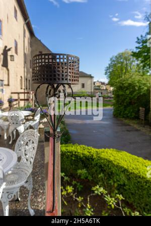 Vadstena, Suède - 23 mai 2021 : un vieux porte-bougie en métal noir sur la terrasse de l'hôtel monastère dans la ville suédoise de Vadstena et en arrière-plan coaux Banque D'Images